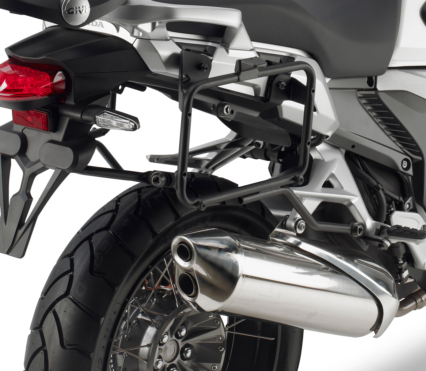 Close-up of a motorcycle's exhaust and rear wheel on a white background