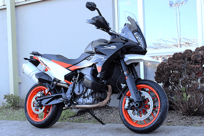 Black white and orange motorcycle in front of building 