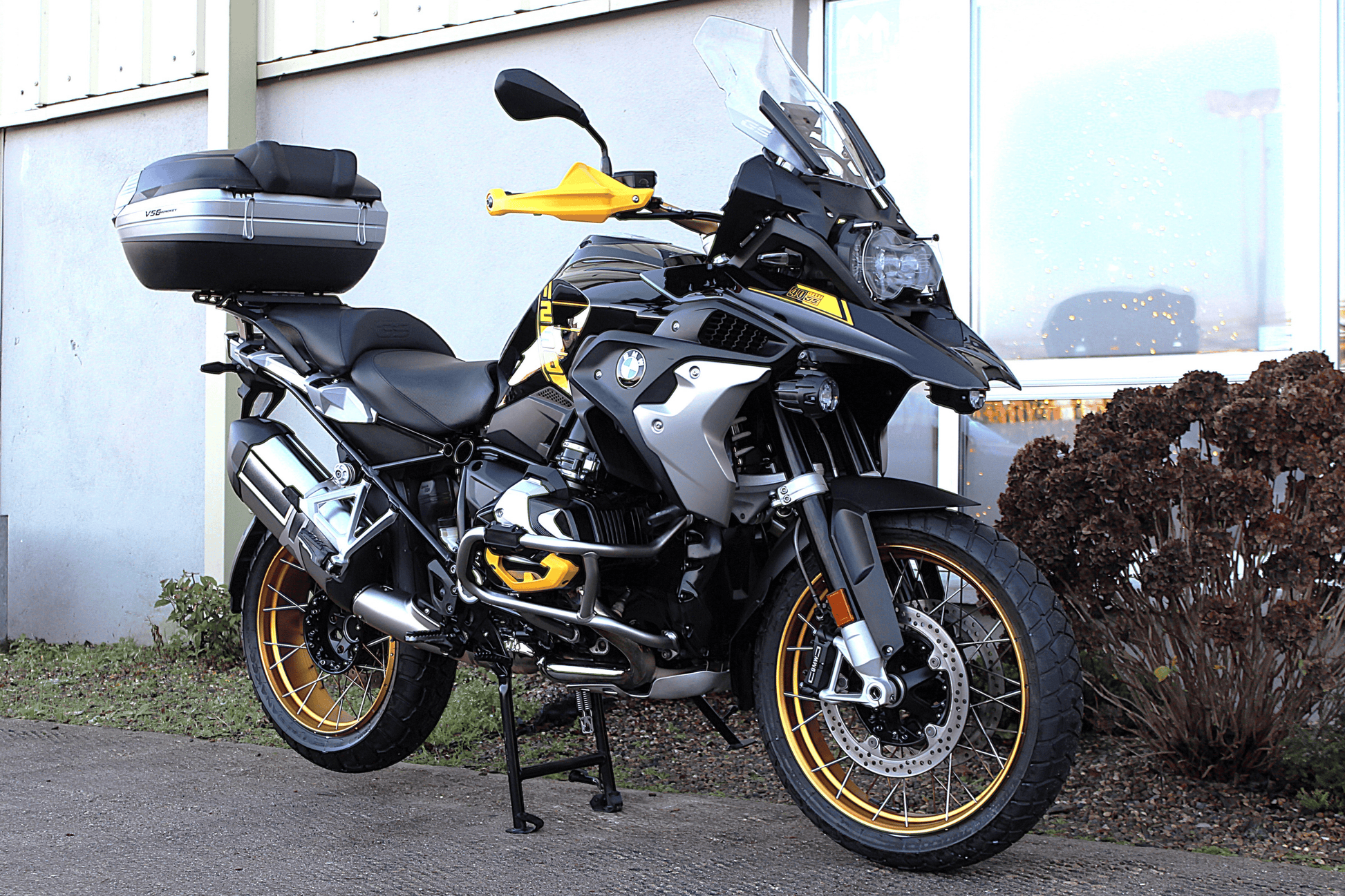 Motorcycle with luggage on a stand in front of a building